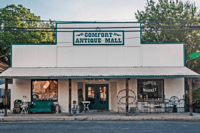 Comfort Antique Mall features a vintage storefront with eclectic outdoor furnishings and signage, highlighting local shopping and antique offerings.